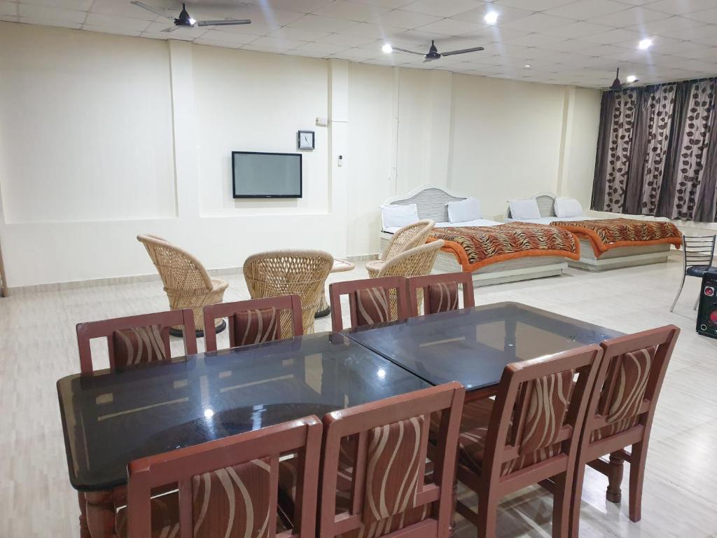 a room with a table and chairs and a couch at Qube House BNB in Rishīkesh