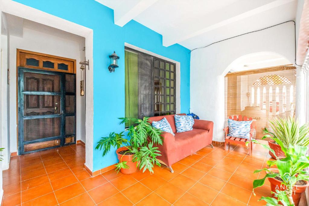 a living room with blue walls and a red couch at Malecon Beach House in Progreso 1 block from beach in Progreso