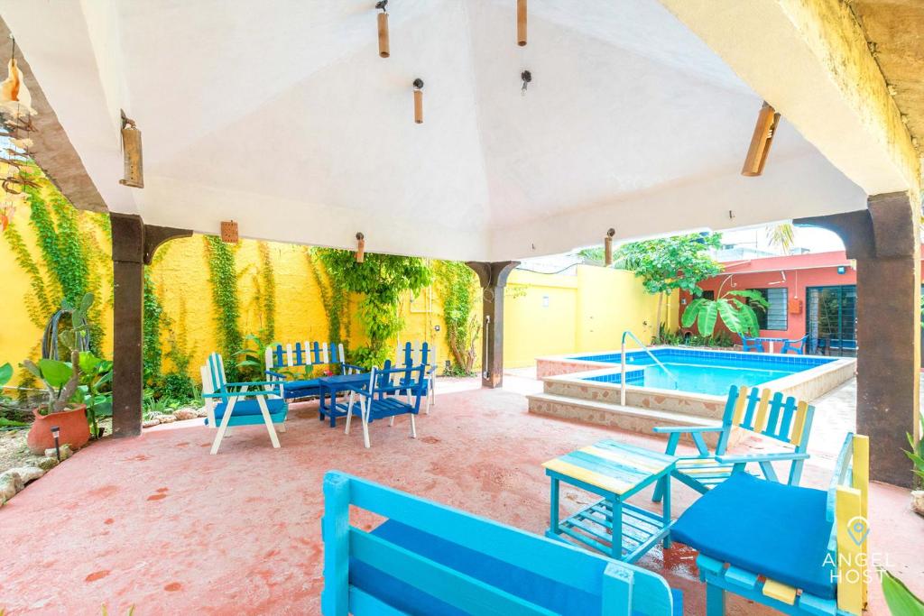 a patio with blue chairs and a swimming pool at Malecon Beach House in Progreso 1 block from beach in Progreso
