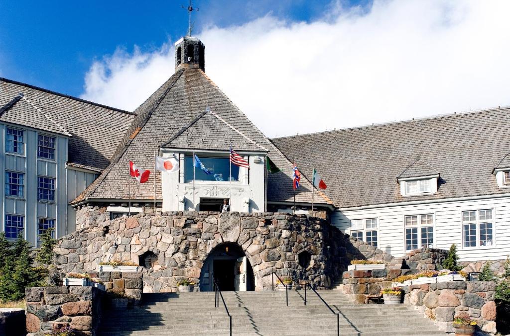 a large stone building with a flag on it at Timberline Lodge in Government Camp