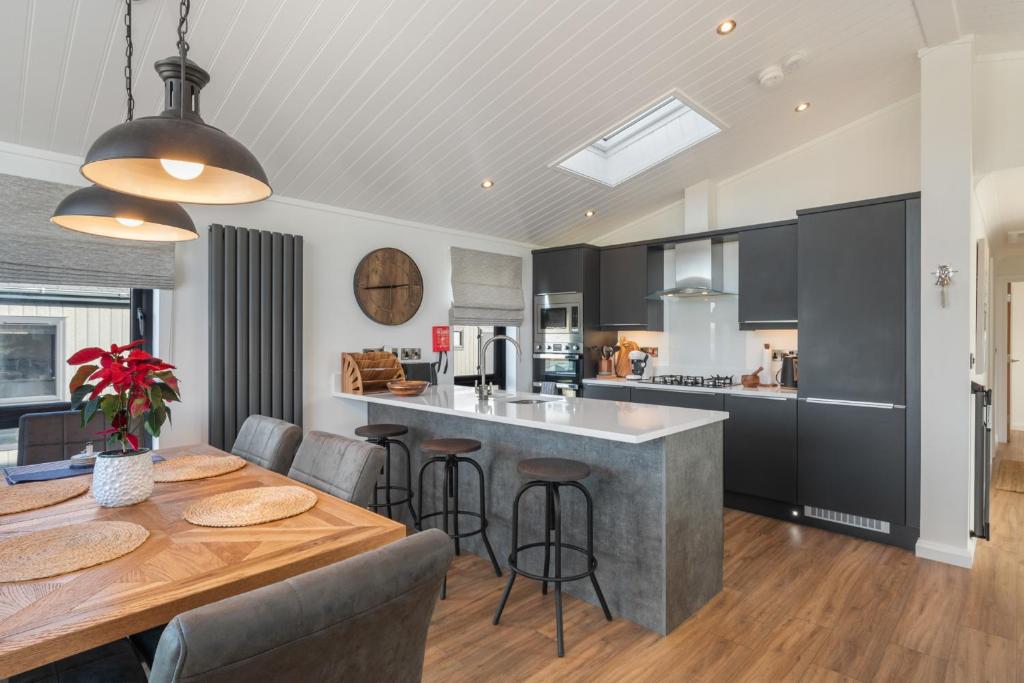a kitchen and dining room with a table and chairs at Hiraeth - Luxury Lodge with Hot Tub, Close to Beach in Penally