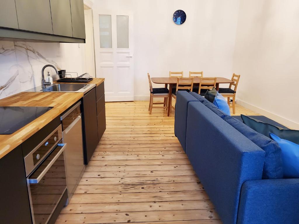 uma sala de estar com um sofá azul e uma mesa em Centrum Apartament Stylowy em Świdnica