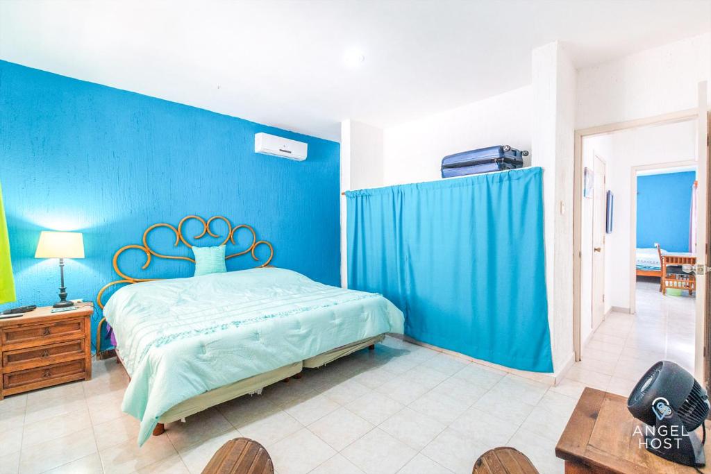 a blue bedroom with a bed and a blue wall at Malecon Beach House in Progreso 1 block from beach in Progreso