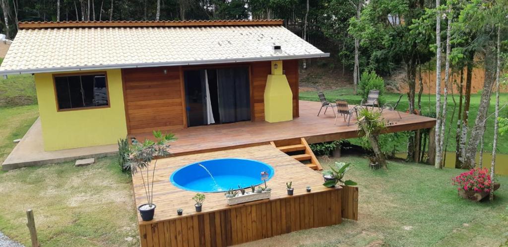 a house with a deck with a swimming pool at Recanto Della Mata in Venda Nova do Imigrante
