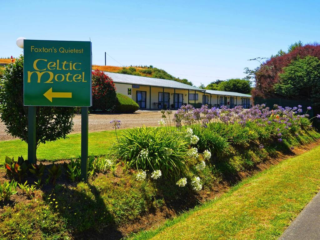 a sign in front of a building with flowers at Celtic Motel in Foxton