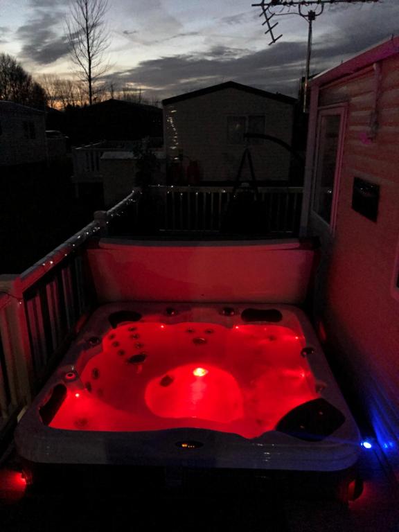 a red bath tub sitting on top of a balcony at Static Caravan with hot tub in Tattershall