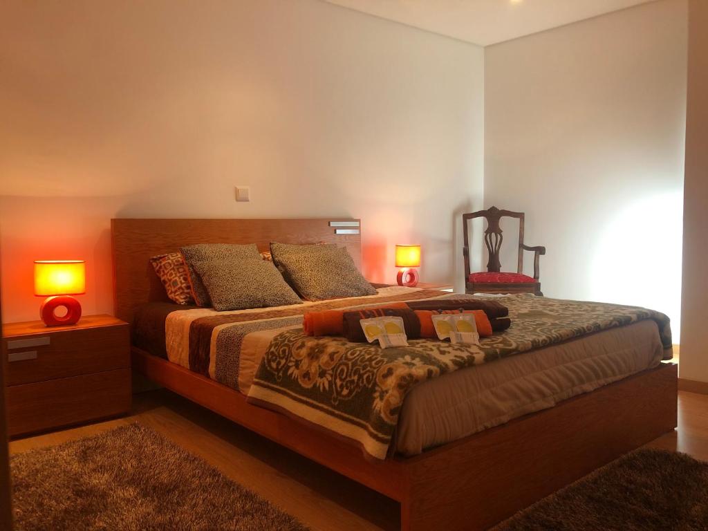 a bedroom with a large bed with two lamps at Casa do Palheiro in Pitões das Júnias