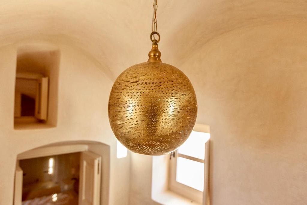 una luz orbe dorada colgando del techo en Castelli Torre, en Emporio