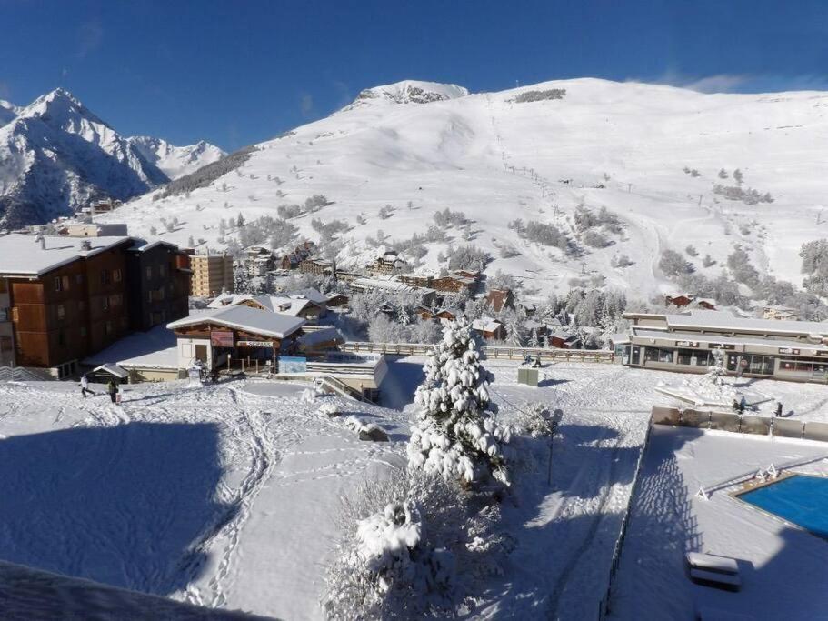 un complexe dans la neige avec une montagne en arrière-plan dans l'établissement Appartement au pied des pistes, à Les Deux Alpes