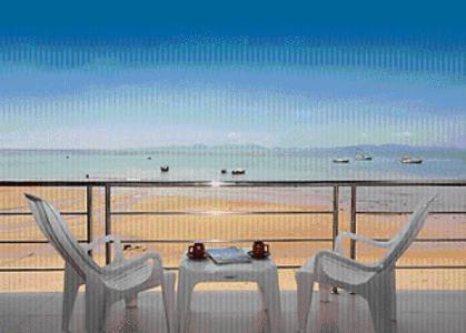 a table and chairs on a balcony overlooking the beach at Koh Kwang Seaview in Klong Muang Beach