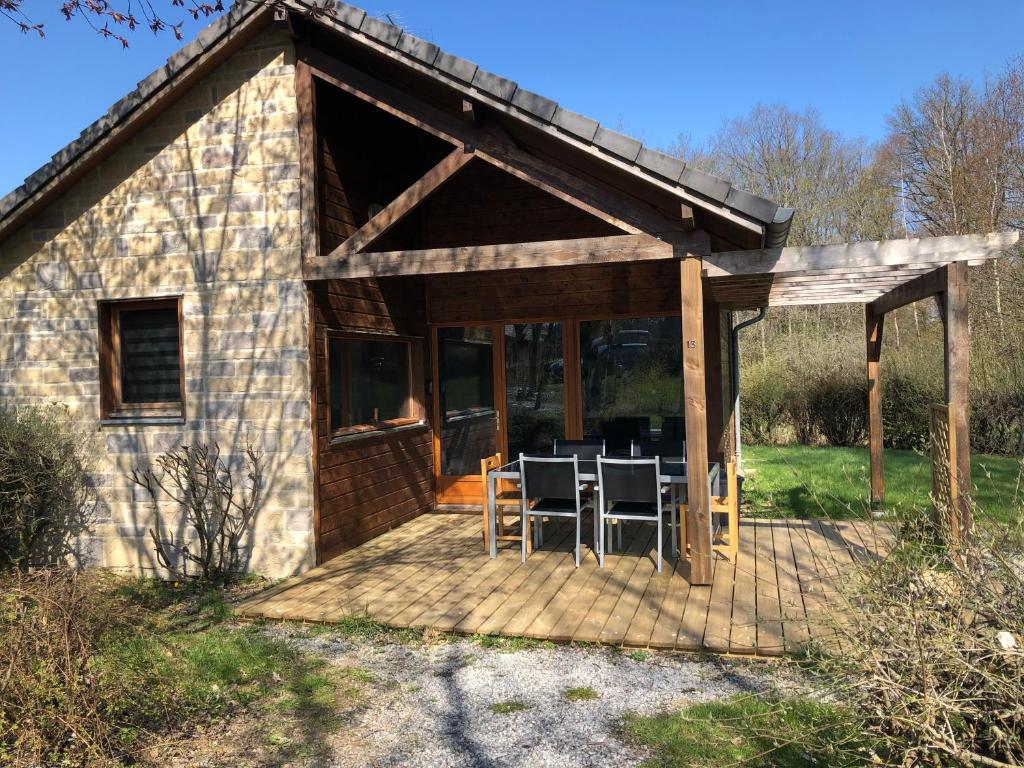 a cottage with a table and chairs on a deck at Cottage 4 personnes dans domaine privé in Signy-le-Petit