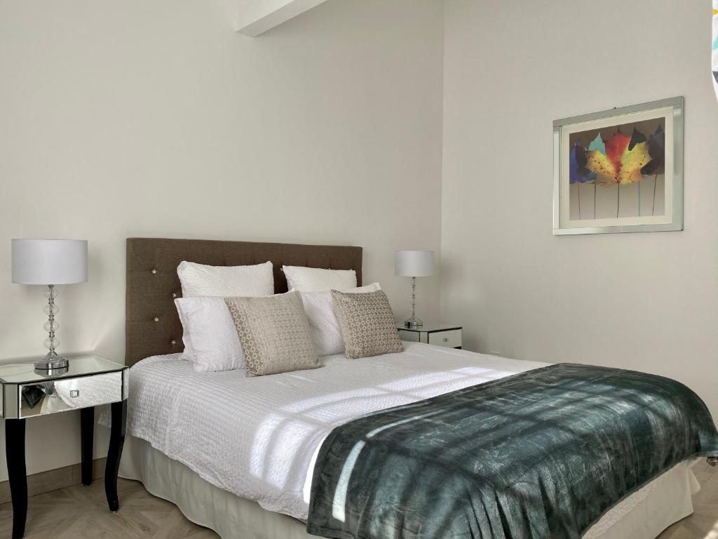 een slaapkamer met een groot bed met witte lakens en kussens bij Manoir et Appartements avec piscine au Domaine de Bize Mirepoix in Mirepoix