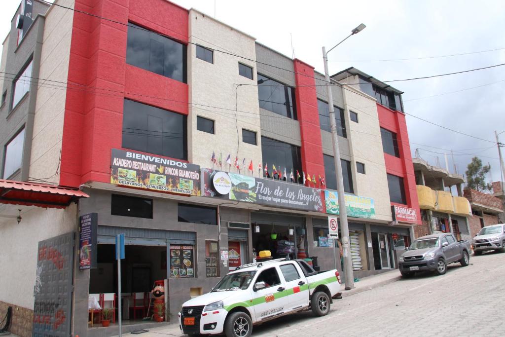 um camião branco estacionado em frente a um edifício em Hostal Flor de los Ángeles em Guamote