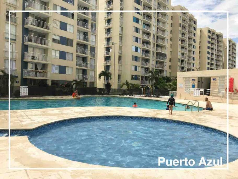 uma grande piscina em frente a alguns edifícios de apartamentos em Hermoso apartamento en club house em Ricaurte