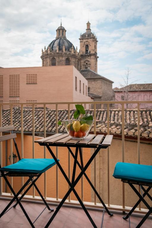 Hotel Niños Luchando, a table with a bowl of fruit on a balcony at Niños Luchando in Granada