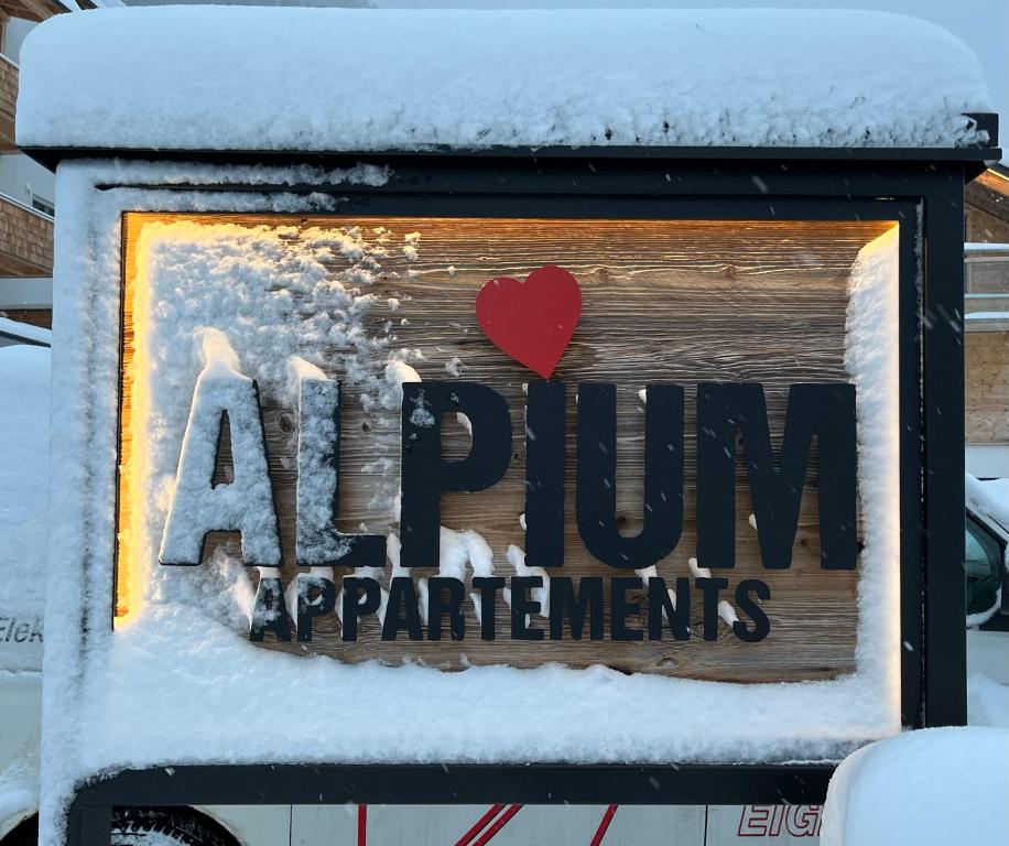 una señal en la nieve con un corazón rojo en ALPIUM - Luxusappartements en Flachau