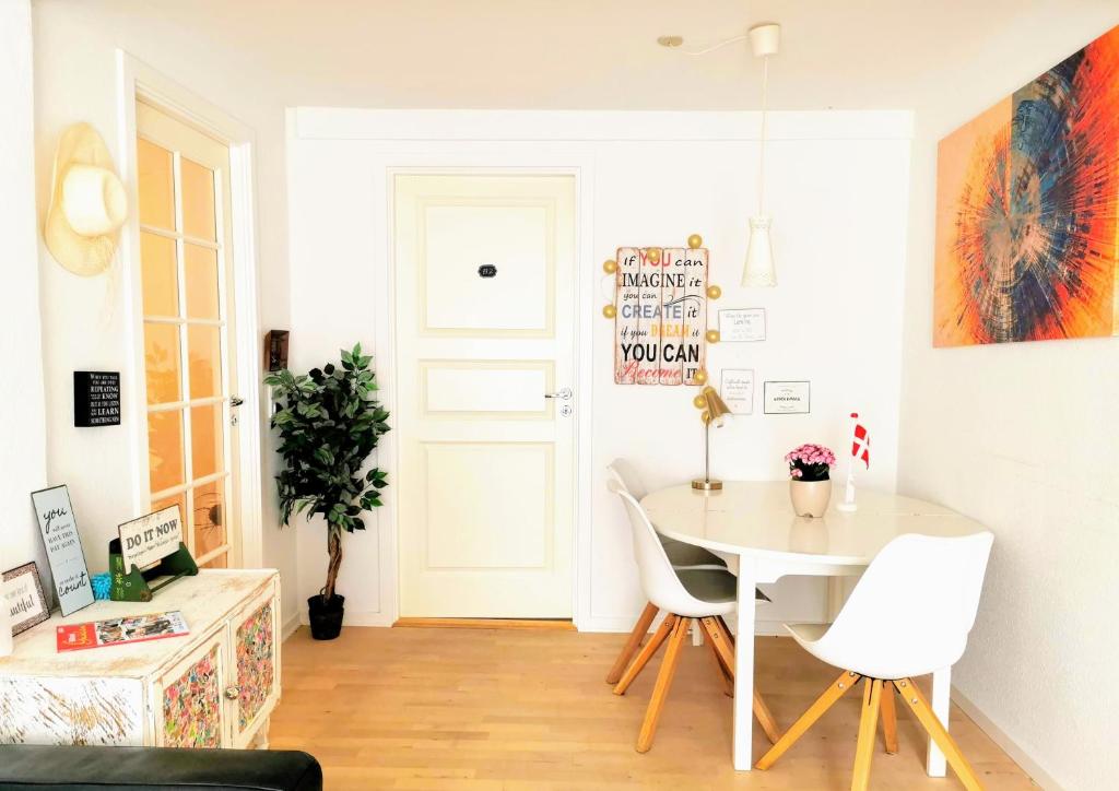 a dining room with a white table and chairs at 300 meter walk to LEGO HOUSE - 80m2 two bedroom apartment with garden - unit B in Billund