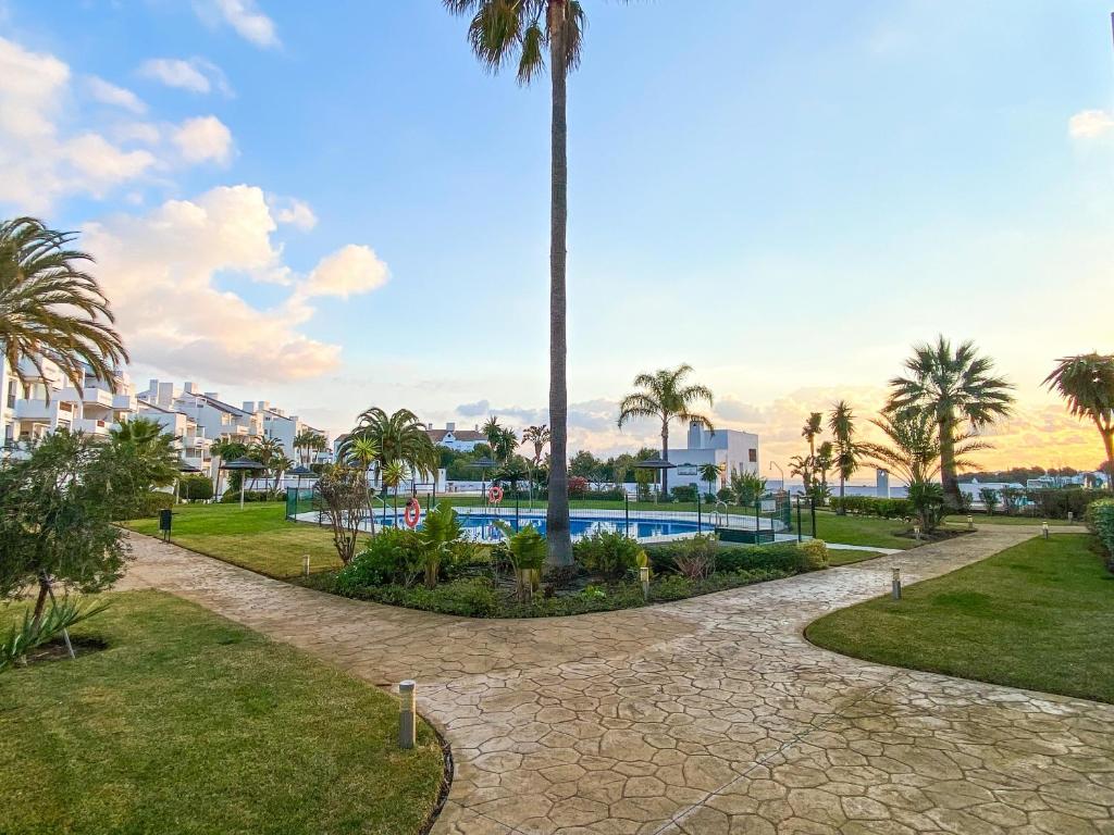 park z palmą i basenem w obiekcie Golf Gardens Miraflores - Bright and spacious apartment w mieście Mijas Costa