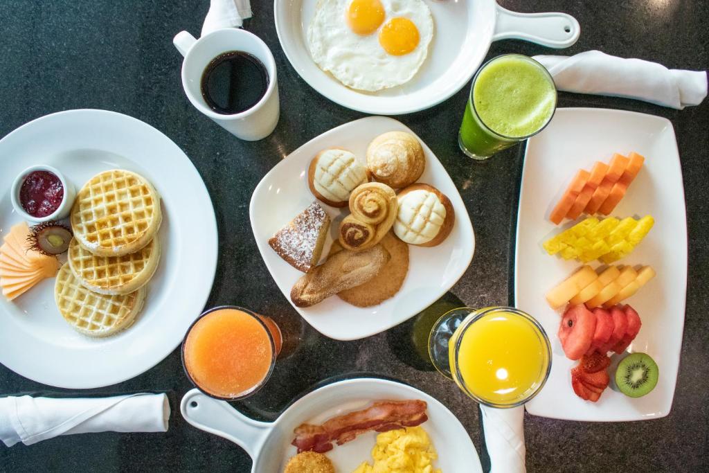 a table with plates of breakfast foods and drinks at Holiday Inn Guatemala, an IHG Hotel in Guatemala