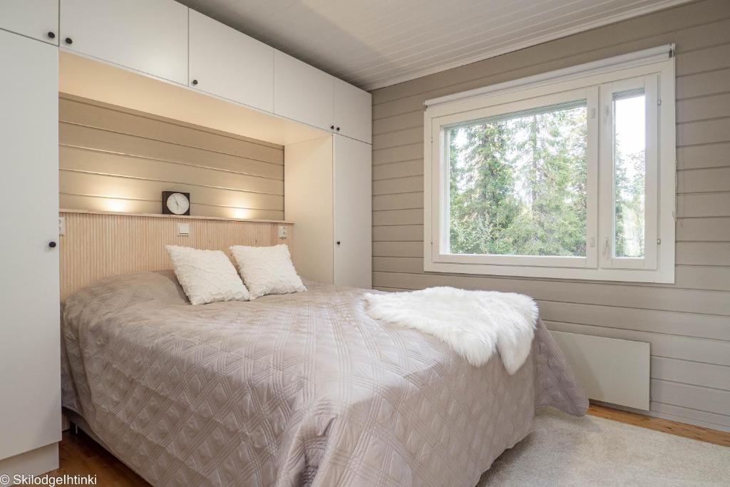 a bedroom with a large bed with a window at RUKA Skilodge Ihtinki, two bedrooms (Free Wi-Fi) in Ruka