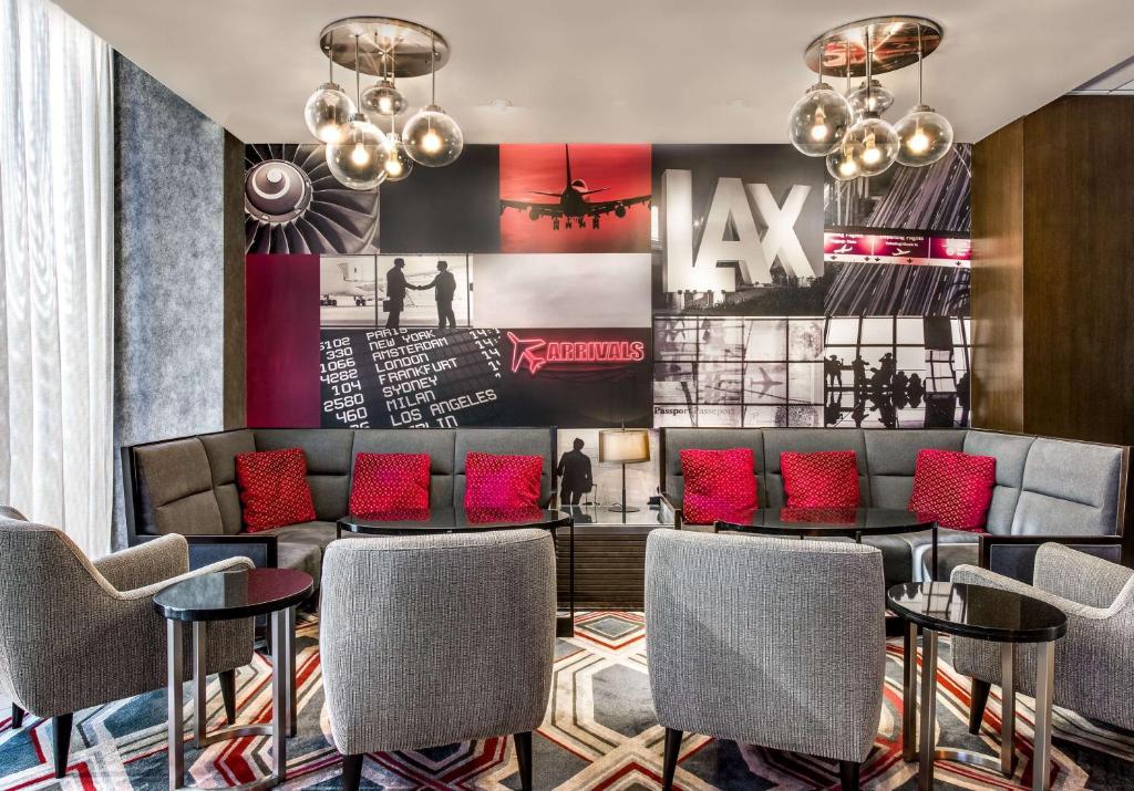 a lobby with a waiting area with chairs and a couch at Sonesta Los Angeles Airport LAX in Los Angeles