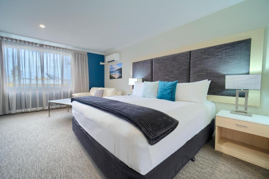 een hotelkamer met een groot bed en een bureau bij Albany Motel & Apartments in Albany