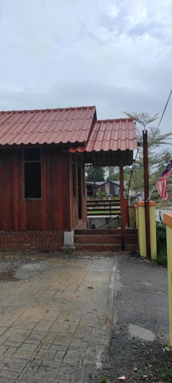 a small building with a red roof and a flag at CHALET KING SUPERIOR in Kota Bharu