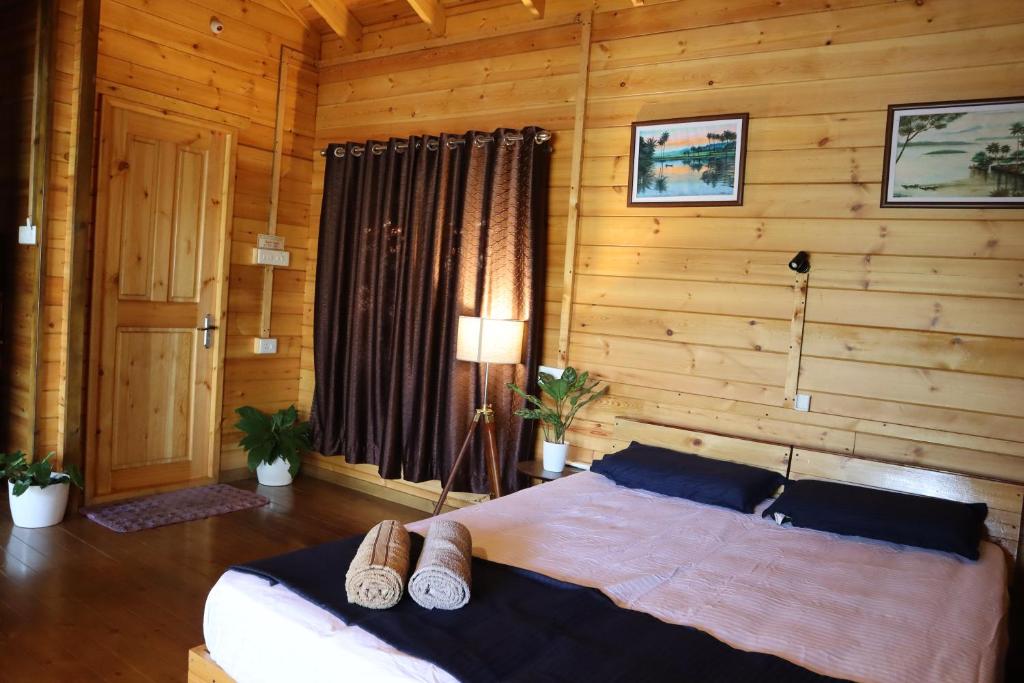 um quarto com uma cama num quarto de madeira em GreenChromide Homestays em Munroe Island