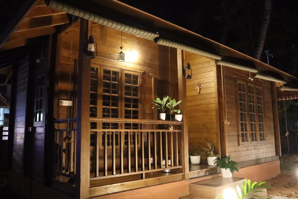 Munroe IslandGreenChromide Homestays的门廊上种有盆栽植物的木屋