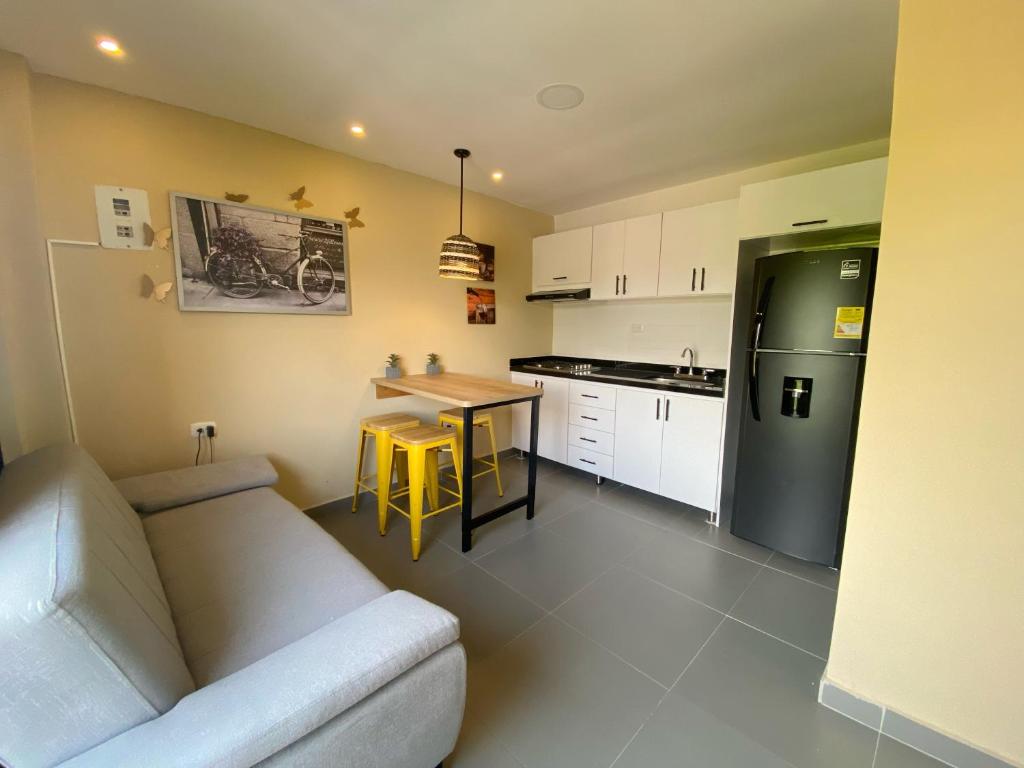 uma cozinha com um sofá, uma mesa e um frigorífico em Apartaestudios - Casa Tamarindo em Aracataca