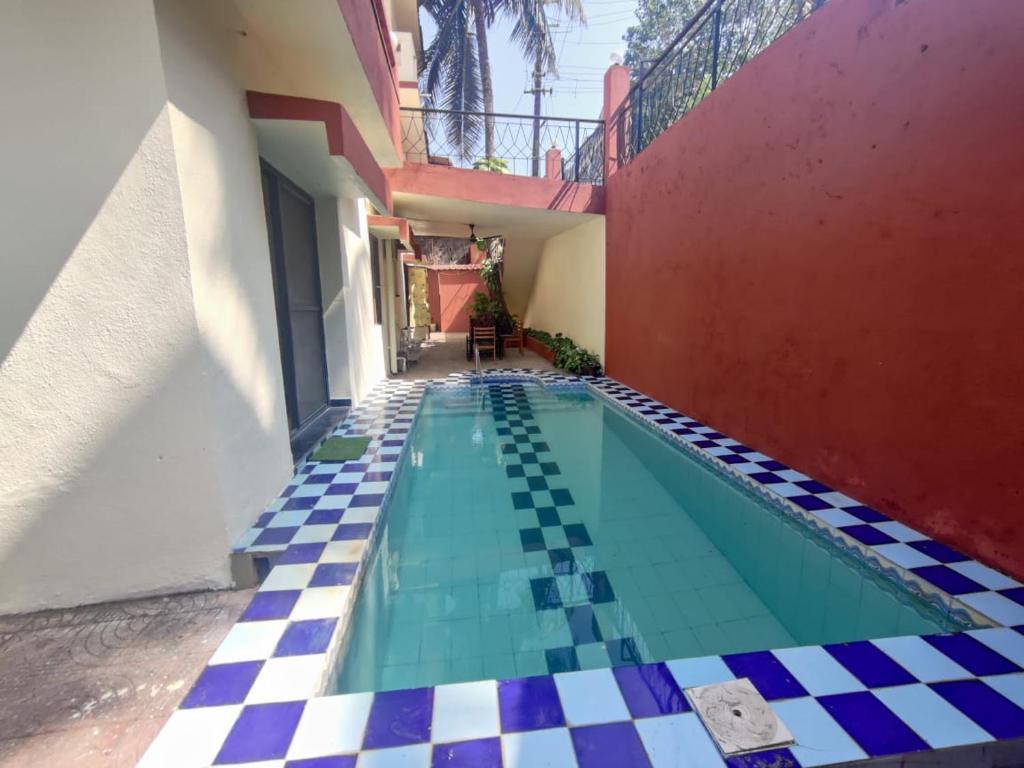 una piscina in una casa con pavimento a scacchi di Amazing Hilltop 3BHK Villa with Swimming Pool a Goa Velha