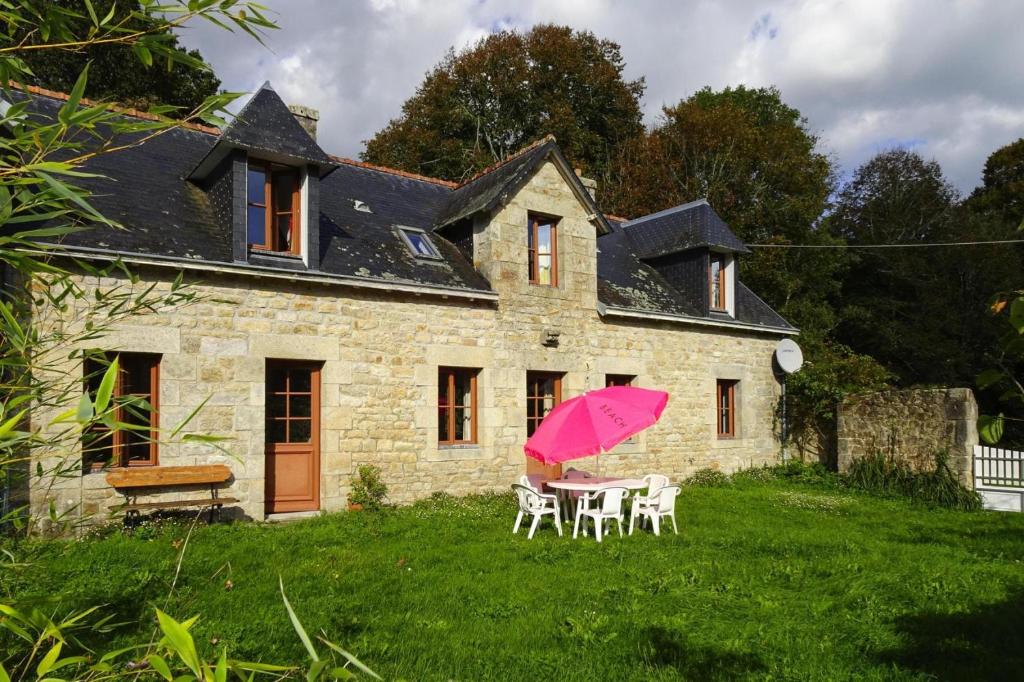 a house with a table and a pink umbrella at Semi-detached house, Bénodet in Bénodet
