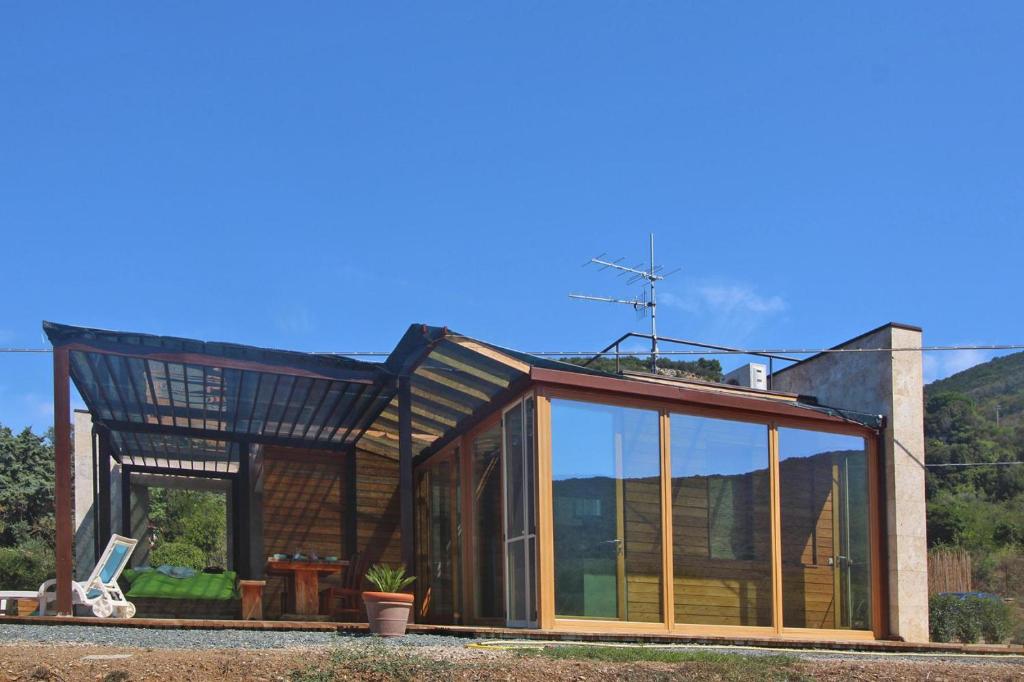 un'estensione di vetro di una casa con tetto di Holiday home Biocasa Fabiana, Portoferraio Magazzini a SantʼAnna
