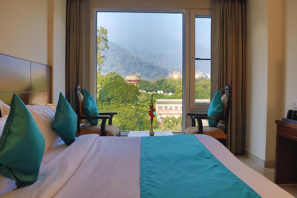 Кровать или кровати в номере Green Hotel - Behind Parmarth Niketan