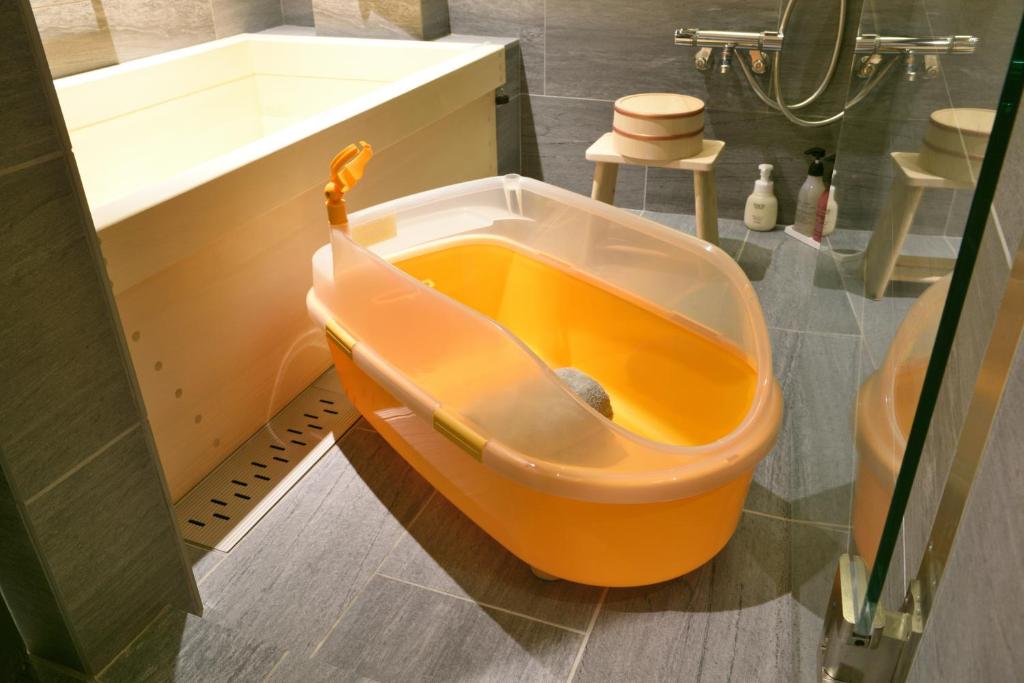 an orange tub in the middle of a bathroom at 染 SEN 五条上長 Gojo Kamicho in Kyoto