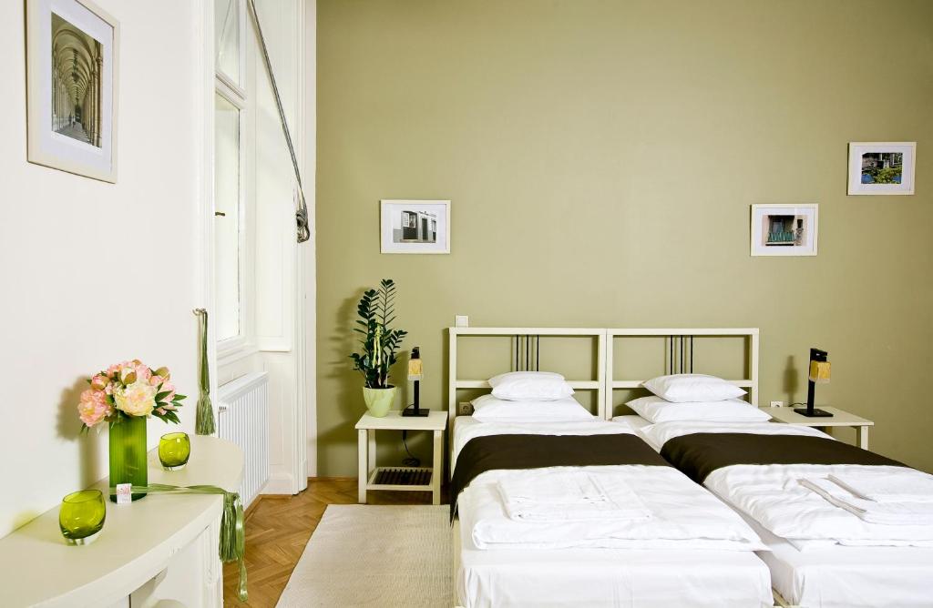 two beds in a room with two tables at Budapest Rooms Bed and Breakfast in Budapest