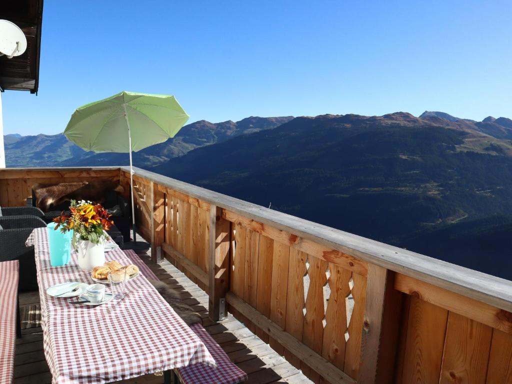 balkon ze stołem i zielonym parasolem w obiekcie Mountain hut right in the Kitzbühel ski area w mieście Mittersill