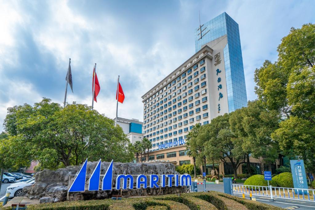 a hotel with flags in front of a building at Maritim Hotel Taicang Garden in Taicang