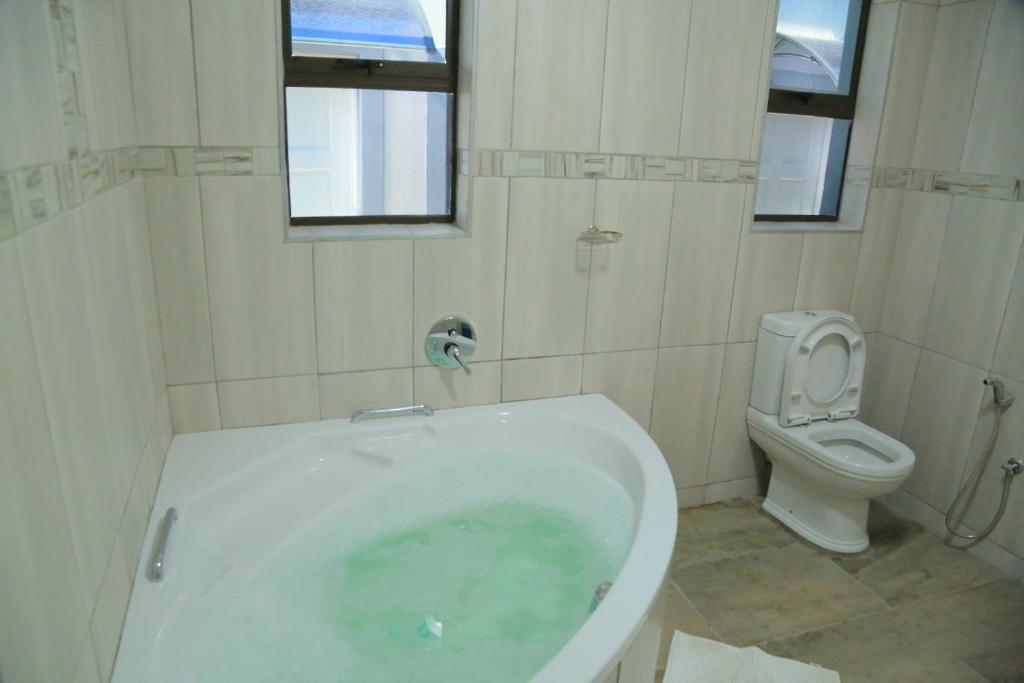 a bathroom with a bath tub and a toilet at Classy Guest House in Johannesburg