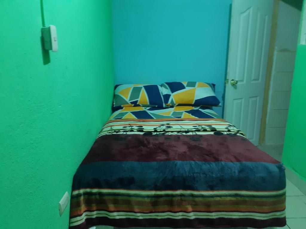 危地馬拉的住宿－HOTEL EL EDEN，一间卧室配有一张带五颜六色棉被的床
