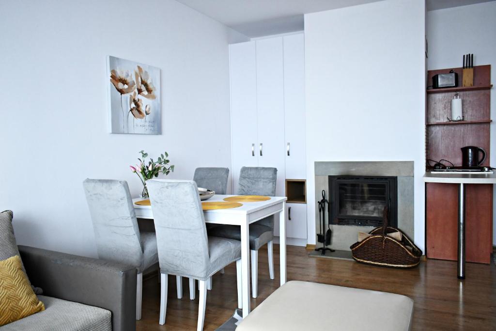 uma sala de jantar com uma mesa e cadeiras e uma lareira em Hodak em Białka Tatrzanska