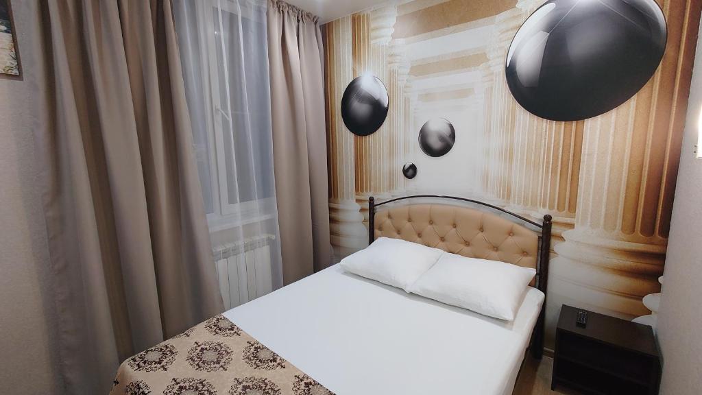 a bedroom with a bed with black balloons on the wall at Apartment App Star in Adler