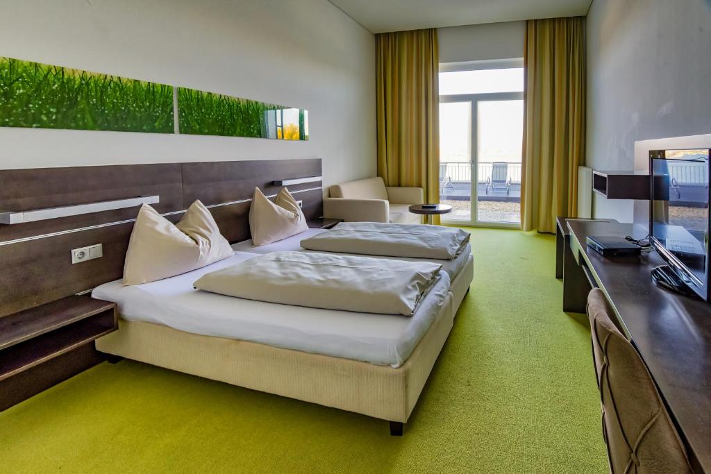 A bed or beds in a room at Neufeldersee Hotel & Restaurant