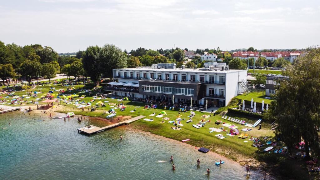 an aerial view of a building next to a body of water at Neufeldersee Hotel & Restaurant in Neufeld an der Leitha