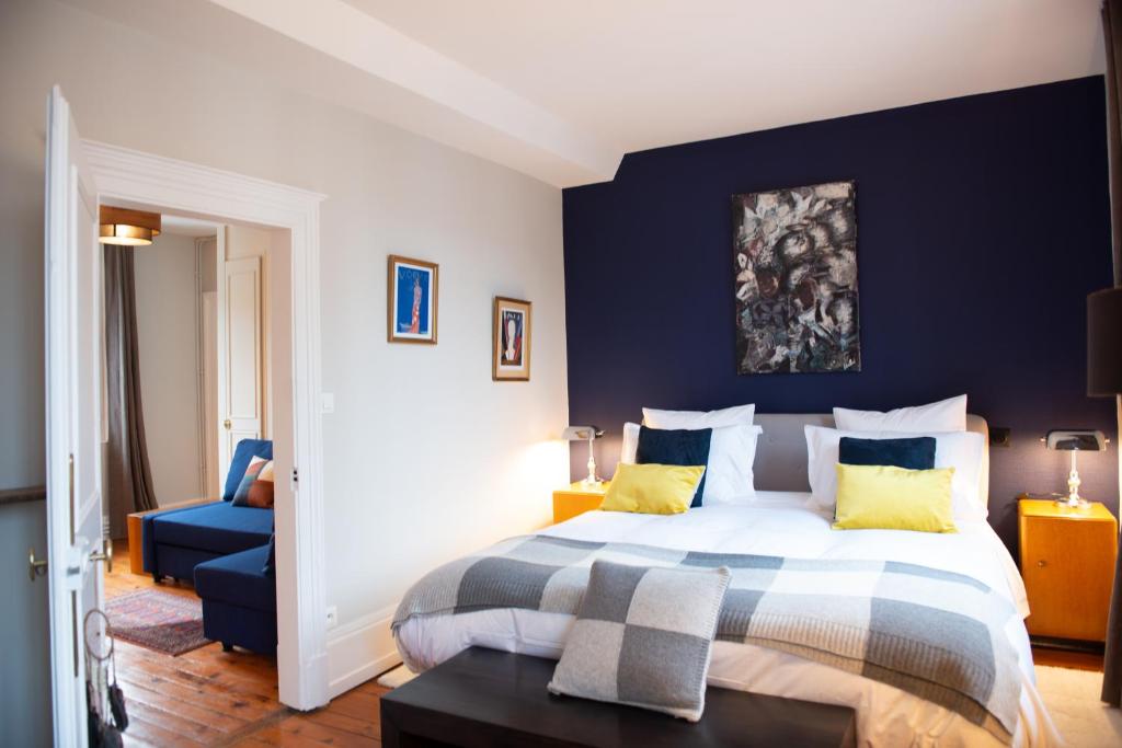 a bedroom with a bed and a blue wall at La Maison Carpe Diem in Les Andelys