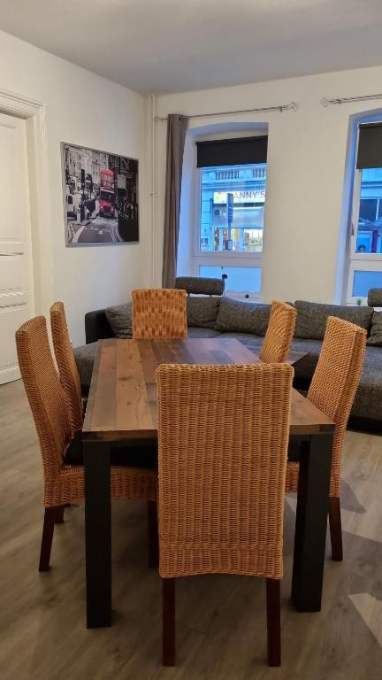 uma sala de jantar com uma mesa de madeira e cadeiras em Stadtnah an der Förde 75 em Flensburg