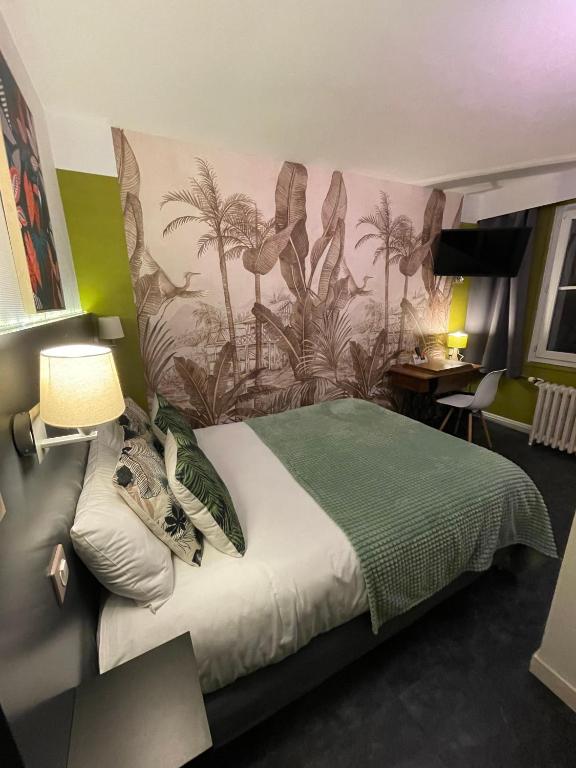 a bedroom with a bed with a painting on the wall at The Originals Boutique, Hôtel d&#39;Angleterre, Le Havre, centre, plage in Le Havre