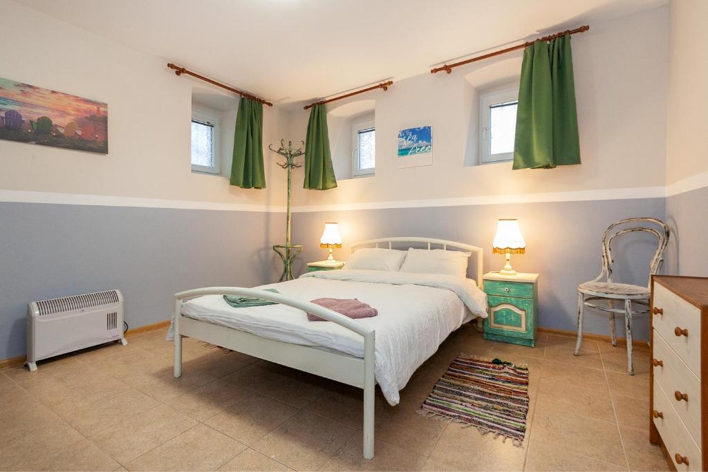 sypialnia z białym łóżkiem z zielonymi zasłonami w obiekcie Nomado Hostel w Warnie