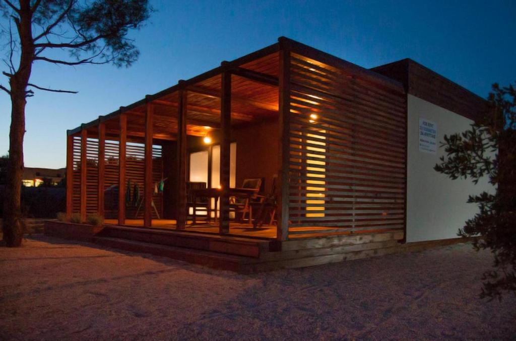 une cabane en bois avec une table la nuit dans l'établissement Mobile Home Sea Shell Šime, Drage, à Drage