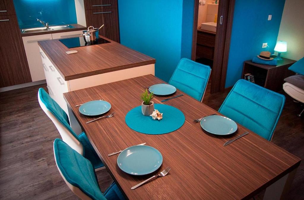 a dining room table with blue plates and chairs at Mobile Home Sea Shell Šime, Drage in Drage
